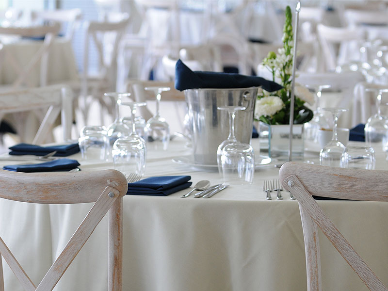 Buttermilk cross back chairs with round tables at a sports hospitality dining event